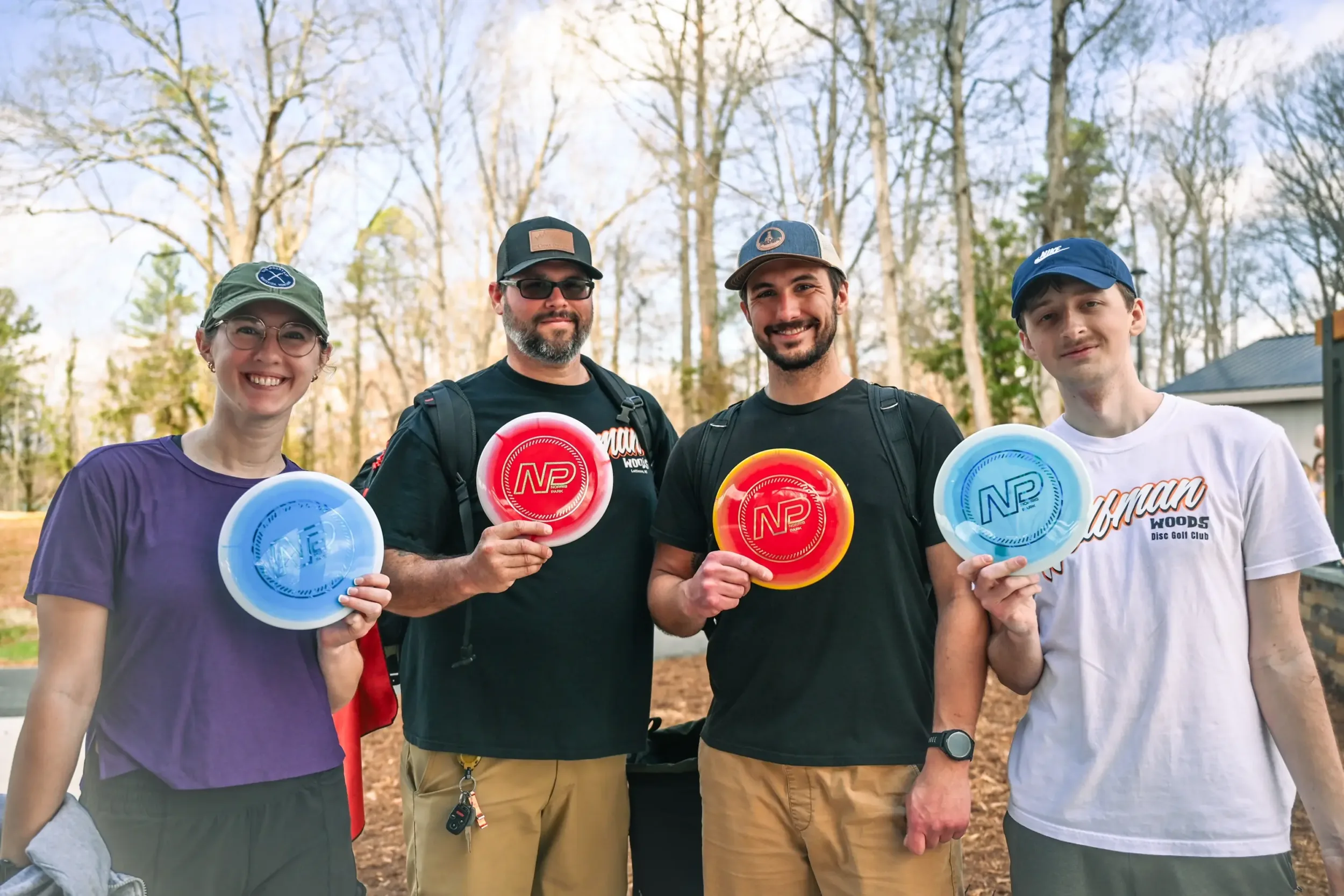 A group of friends holding branded Norris Park discs