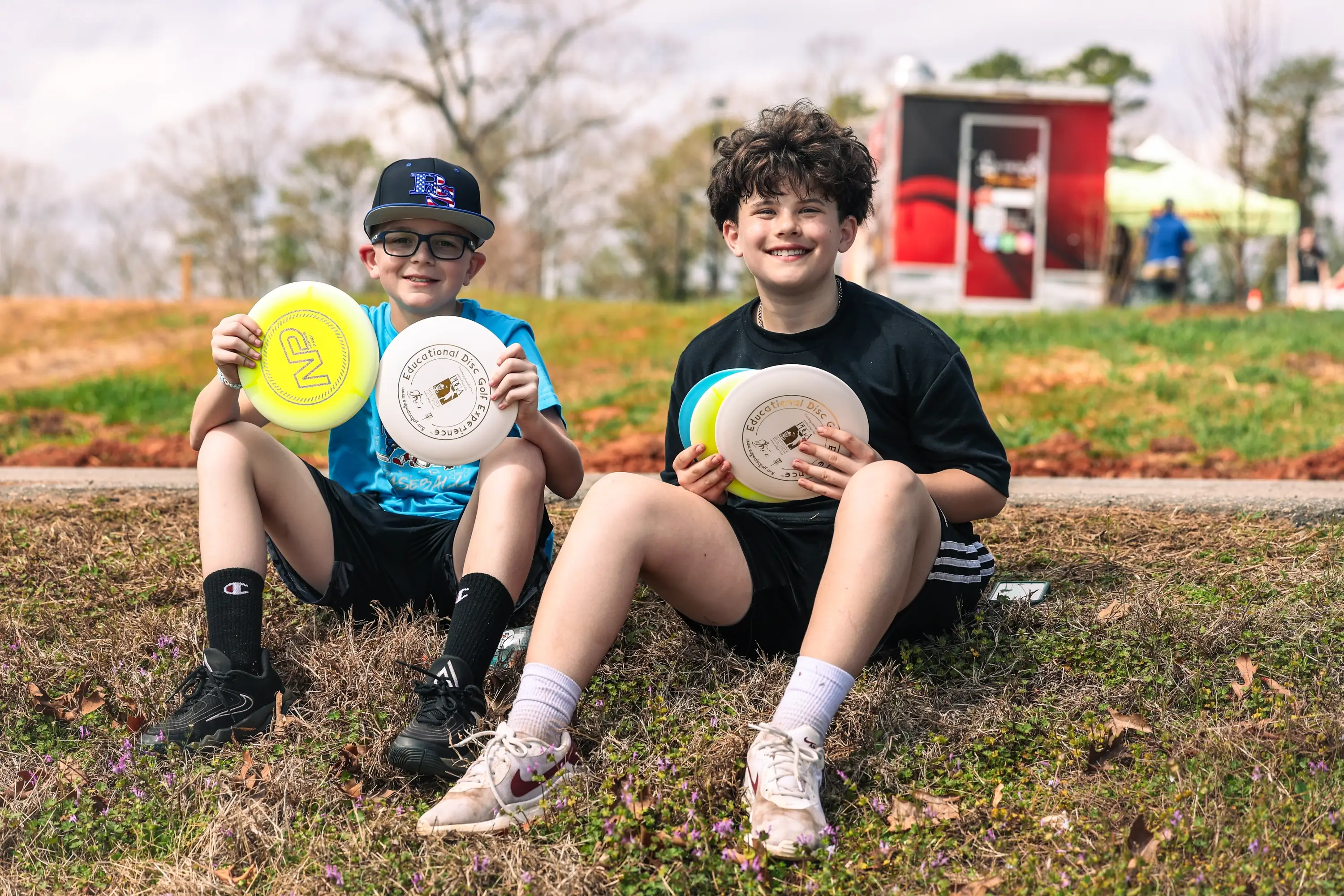 Kids sitting on a bank holding branded discs