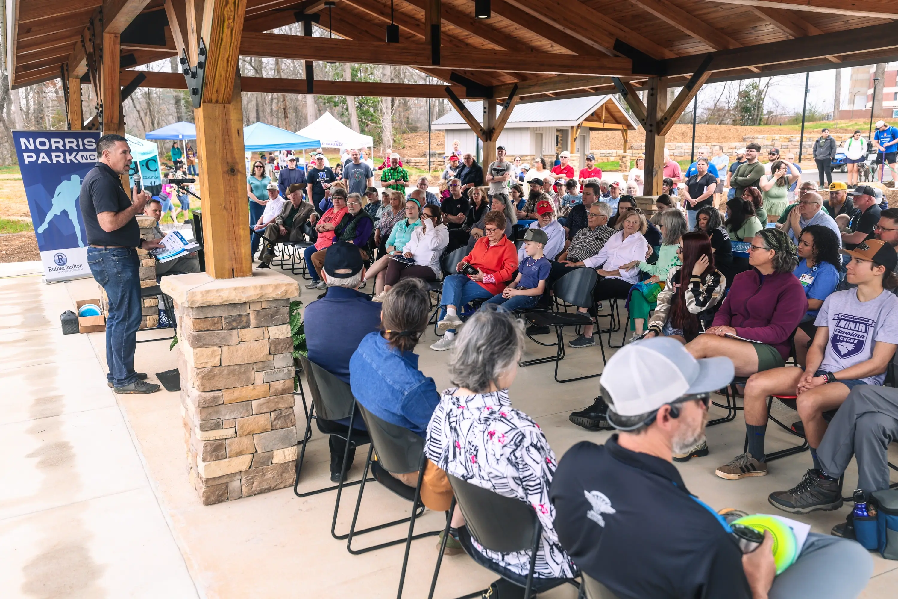A man speaking to a group at a park opening event