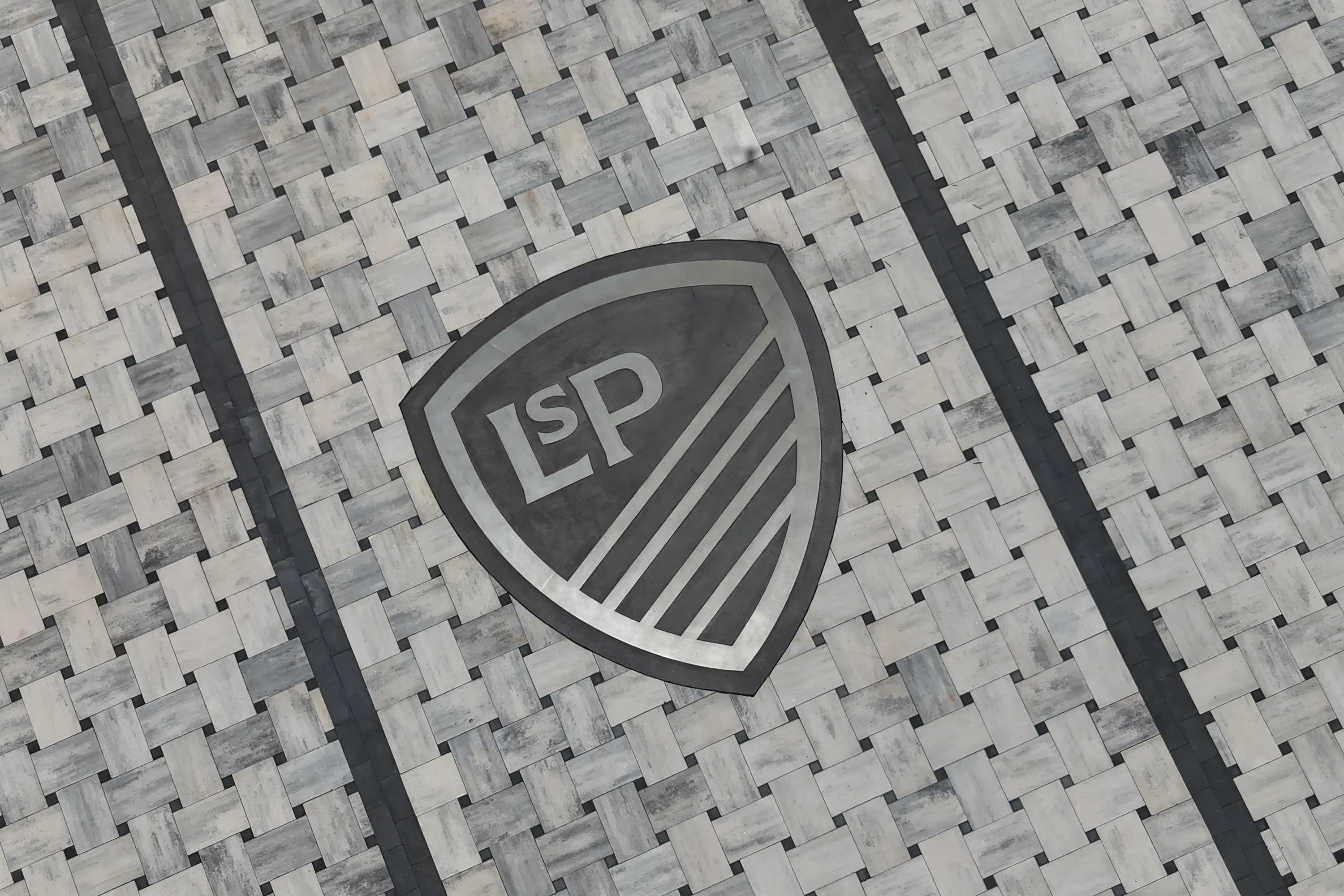 A metal Legacy Soccer Park logo embedded into the ground