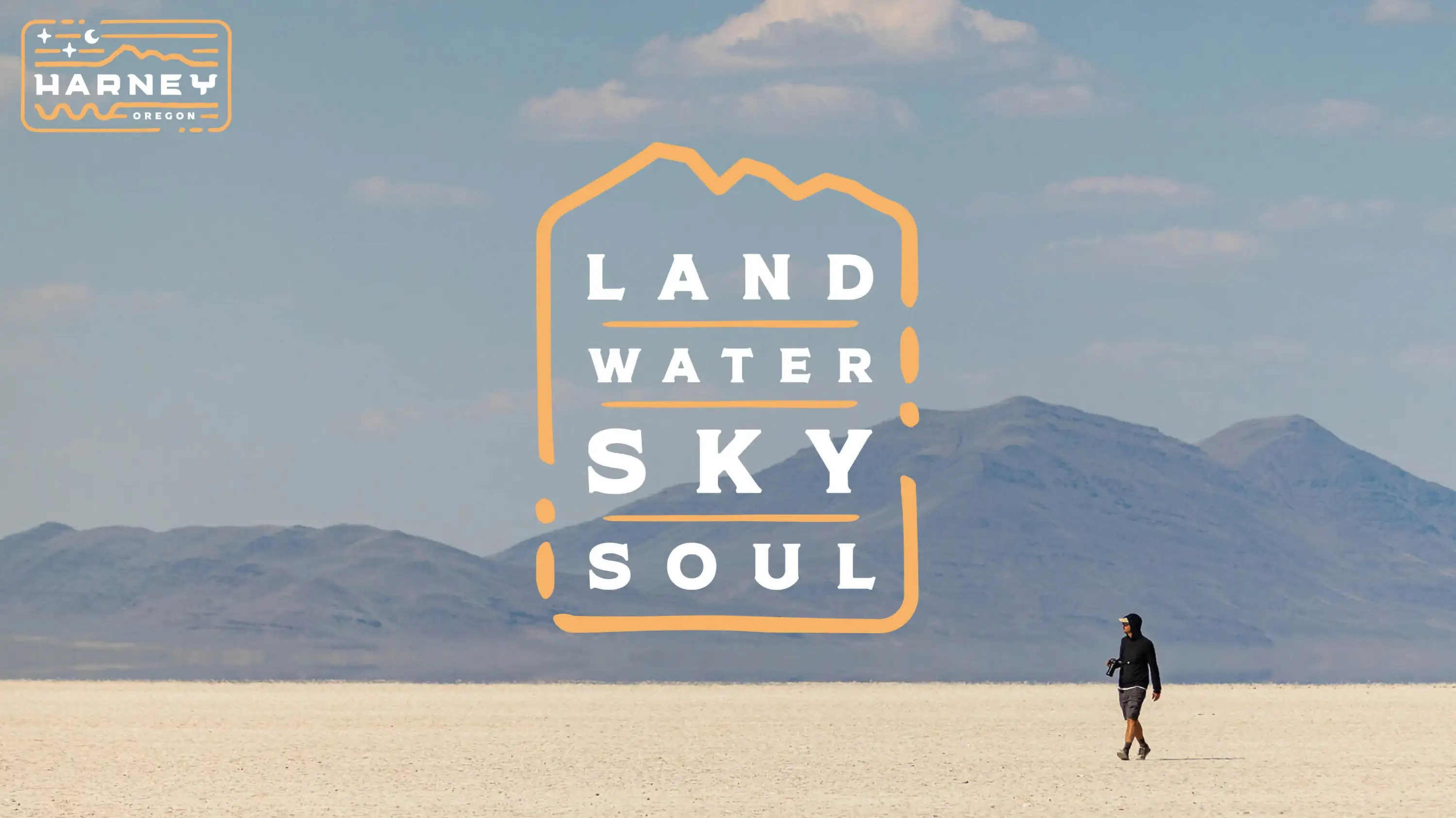 A man walking in the desert with the overlaid text "Land, Water, Sky, Soul"
