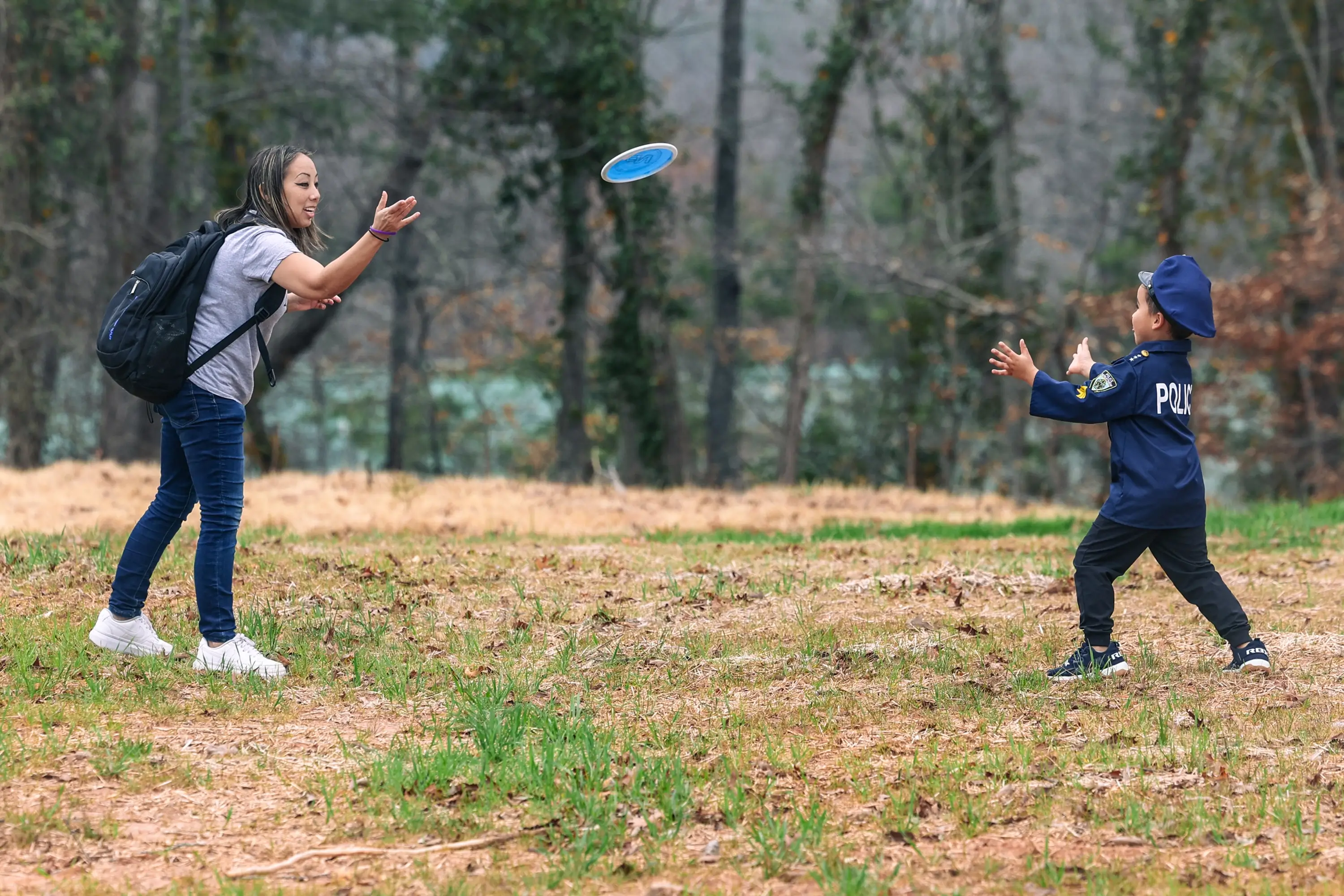 A mother and son throwing a disc back and forth