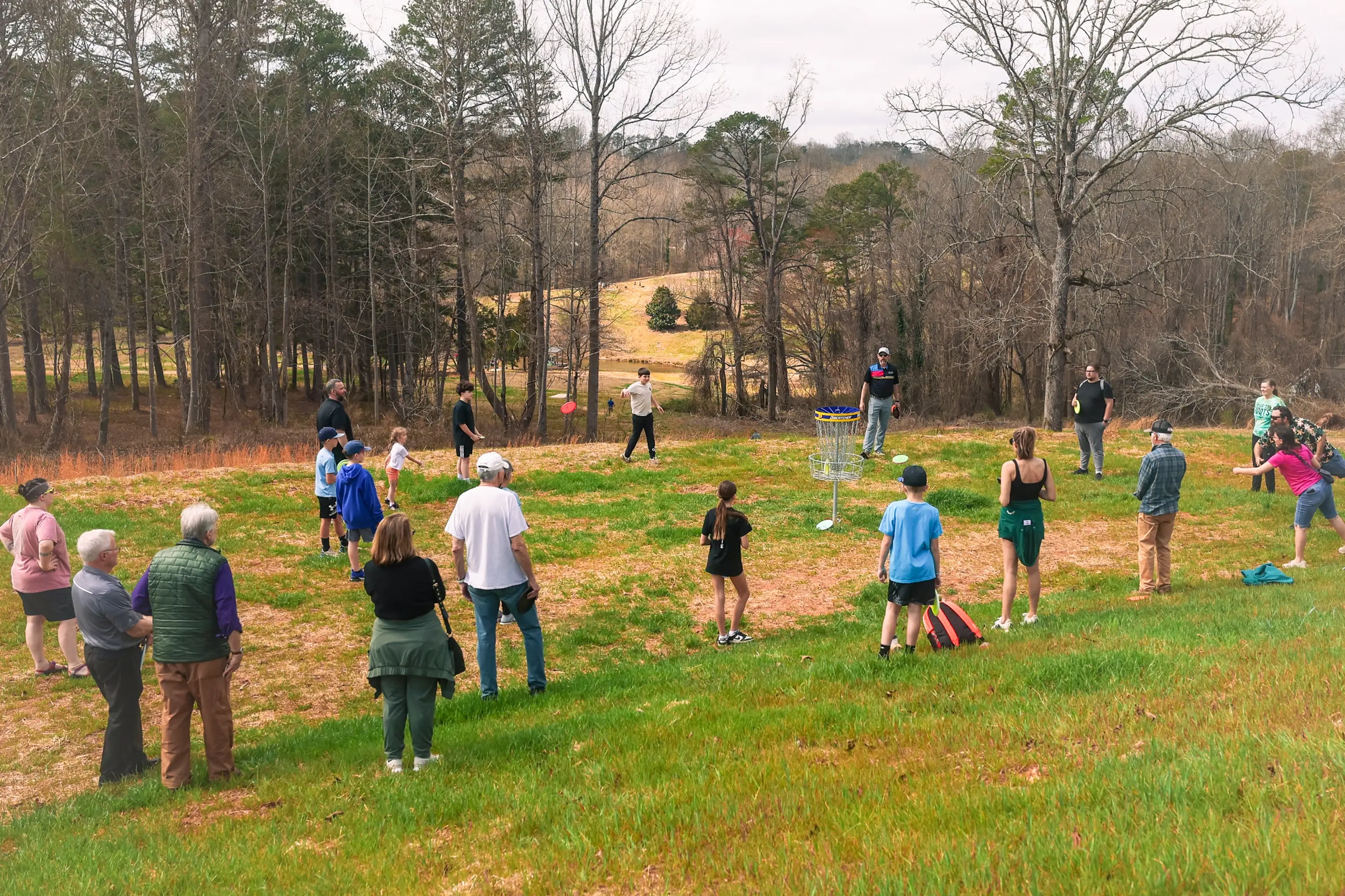 A group of people gathered throwing discs
