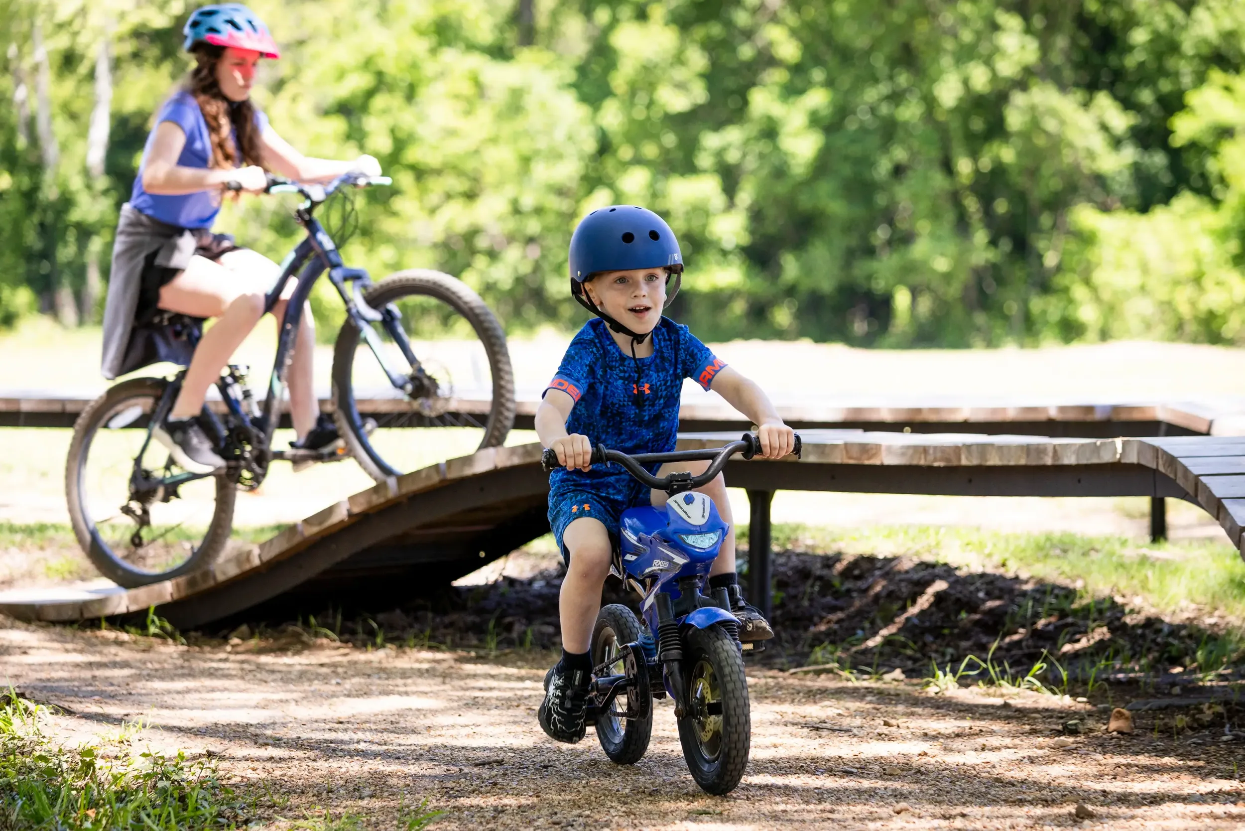 A kid on a bike with a girl on a bike in the background