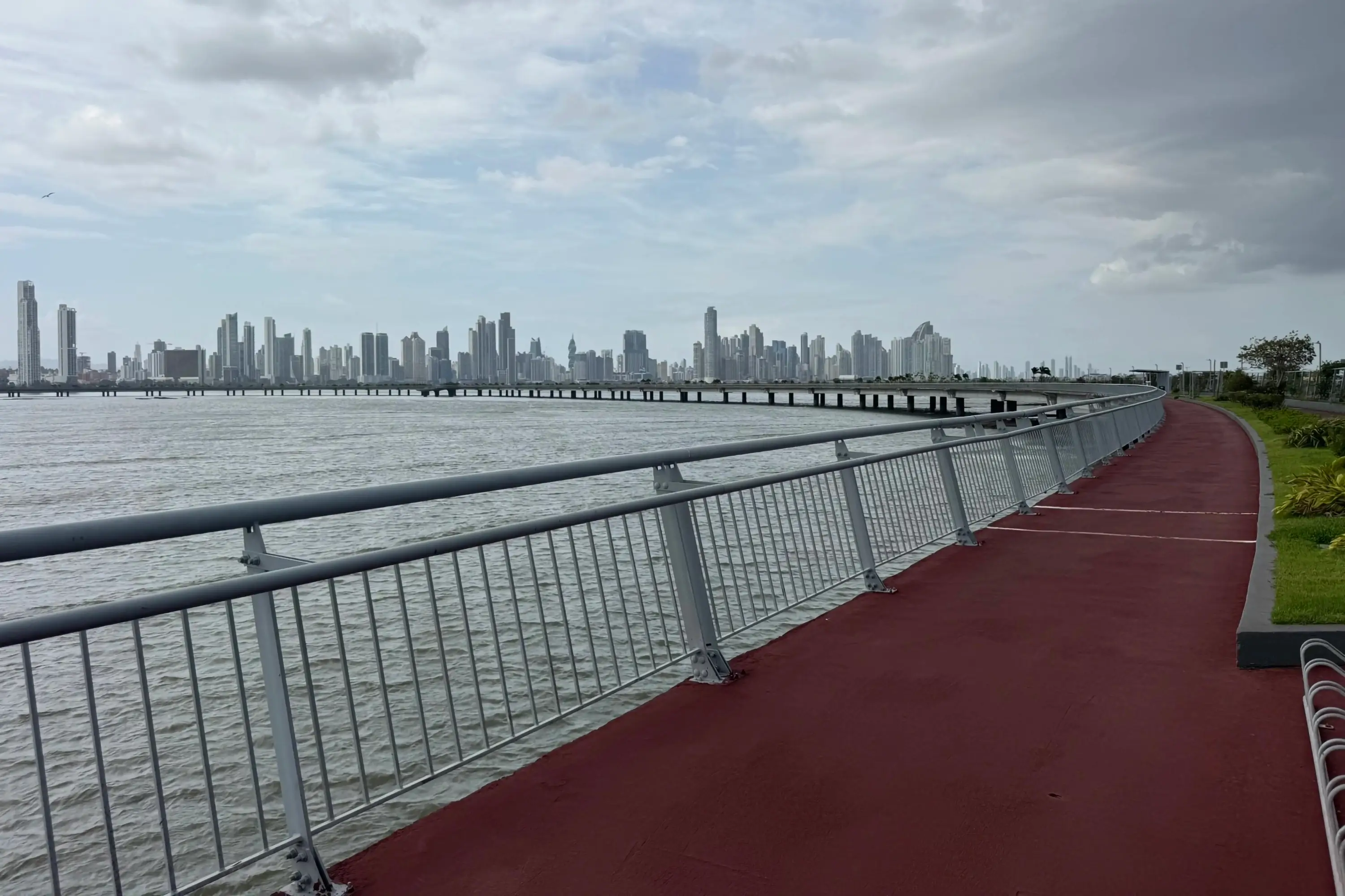 A boardwalk by water with a city in the background
