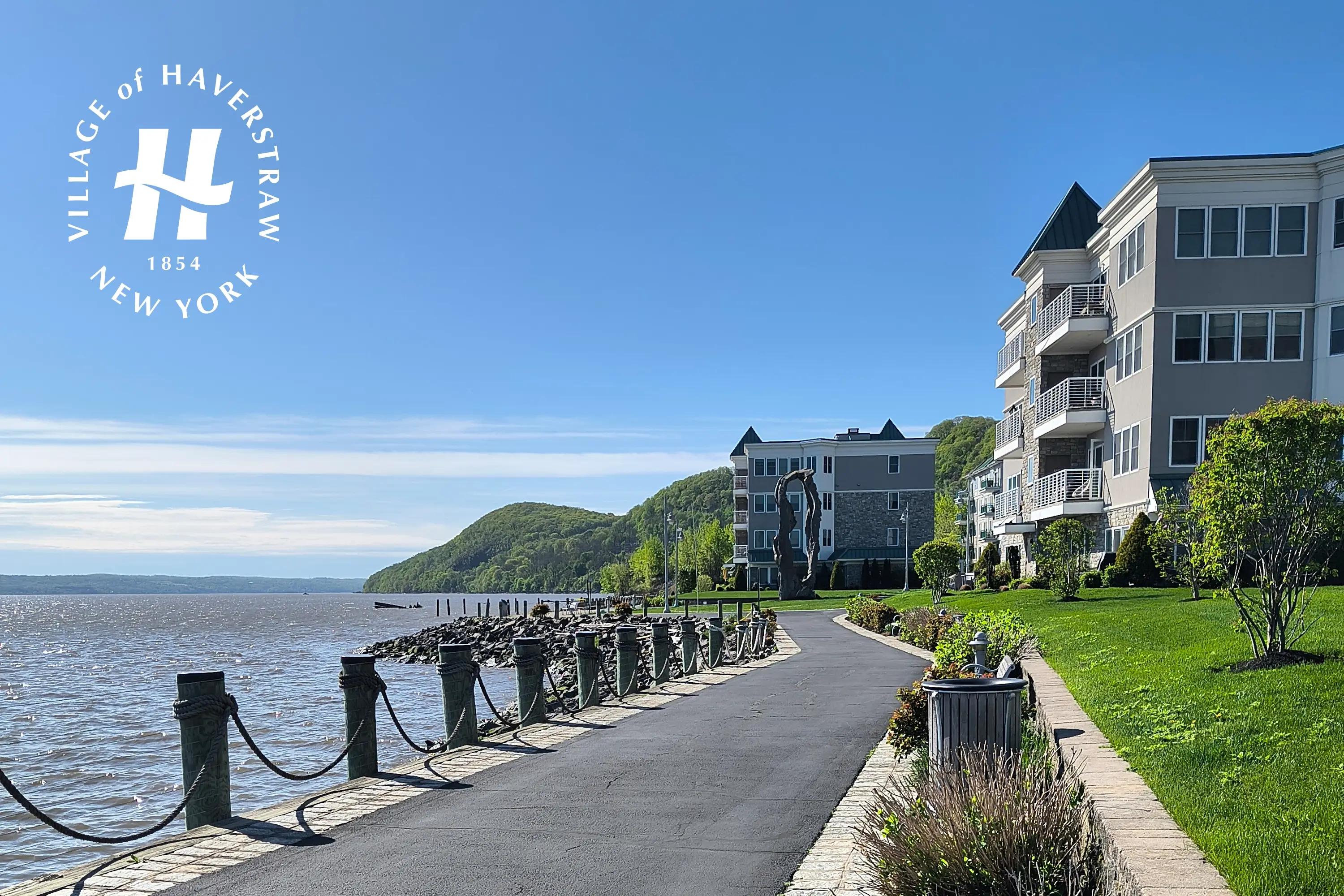 A branded boardwalk view of apartments and water