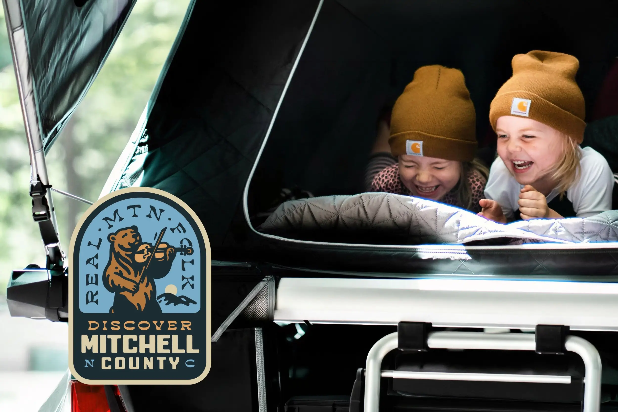 Kids in a tent set up in a car