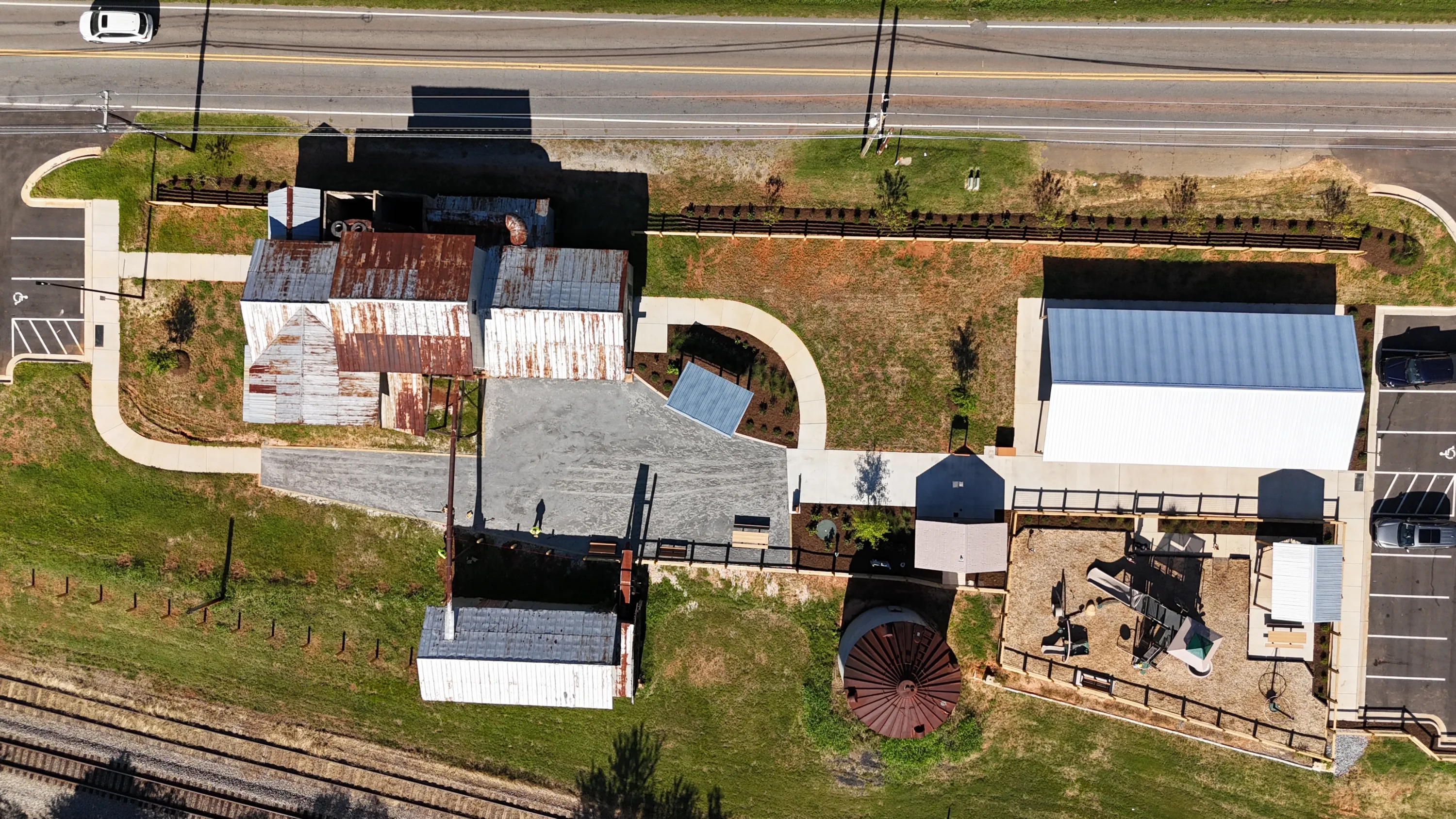 Aerial view of the Colfax Cotton Gin site with gin sheds, a playground, pavilions and parking