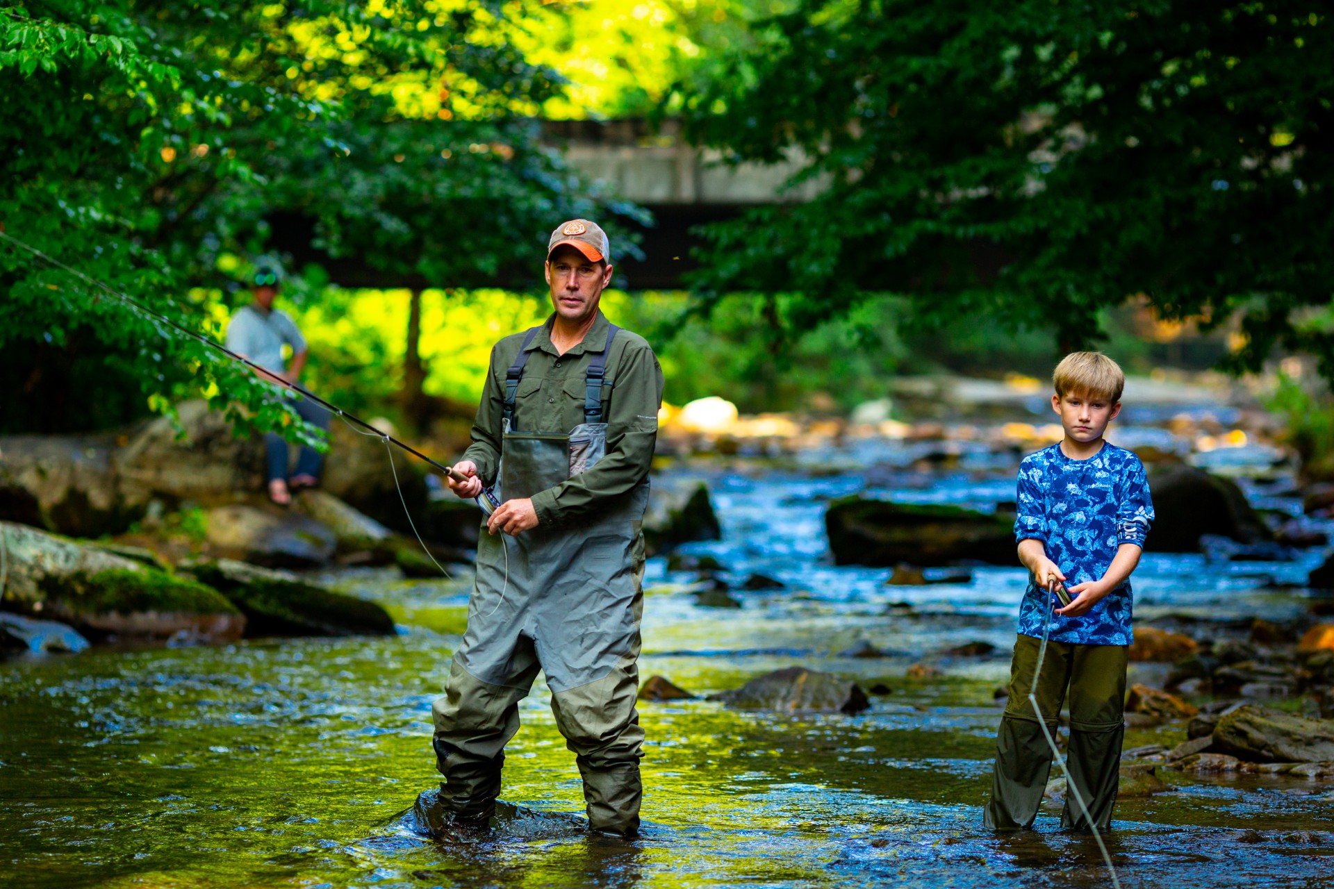 A father and son fishing in a stream